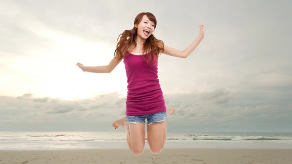 Happy woman jump at the ocean.