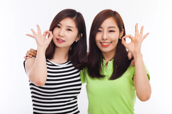 Zwei asiatische junge Mädchen unterzeichnen okay — Stockfoto