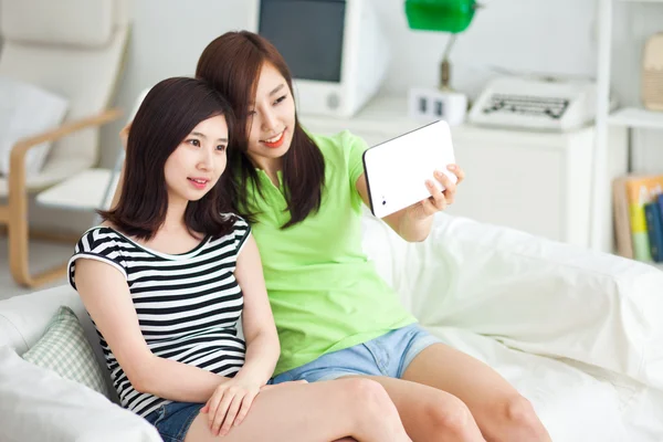 Две азиатские девушки используют планшетный компьютер . — стоковое фото