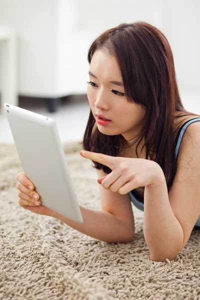 Mulher asiática usando um PC pad no chão . — Fotografia de Stock