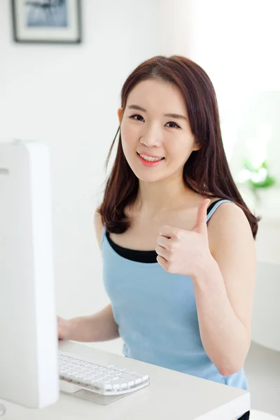 Bilgisayar kullanan mutlu Asyalı genç kadın. — Stok fotoğraf