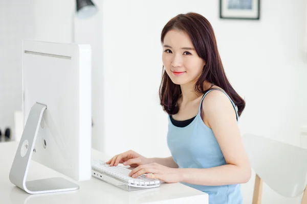 Счастливая азиатская девушка за компьютером . — стоковое фото