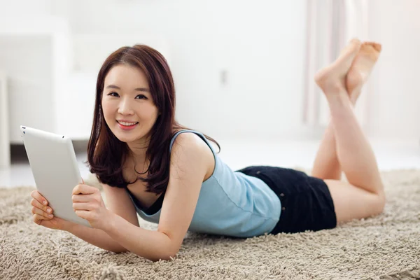Asiática mujer usando un pad PC en el suelo . — Foto de Stock