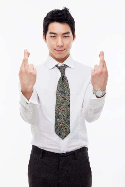 Jovem homem de negócios asiático mostrando sinal de sorte — Fotografia de Stock