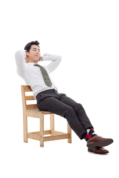 Mladé asijské obchodní muž sedí na židli — Stock fotografie