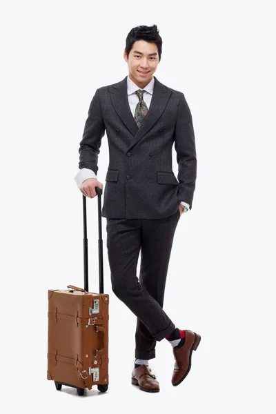 seyahat bavul çekerek boyunca yürüyüş iş adamı