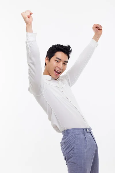 Junger asiatischer Mann zeigt Faust und glückliches Zeichen. — Stockfoto