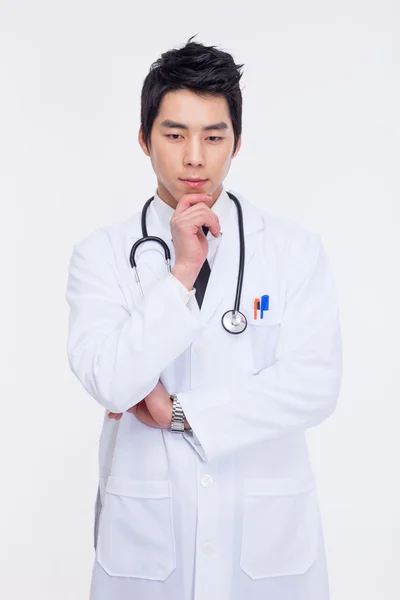Thinking young Asian doctor — Stock Photo, Image