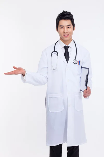 Jonge Aziatische dokter voorstellen iets. — Stockfoto