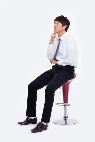 sandalyede oturan genç Asyalı iş adamı