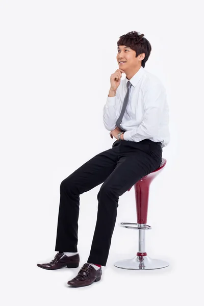 sandalyede oturan genç Asyalı iş adamı