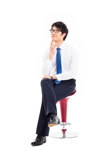 sandalyede oturan genç Asyalı iş adamı