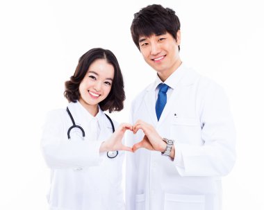 Genç Asyalı doktor kalp şekli gösteriliyor.