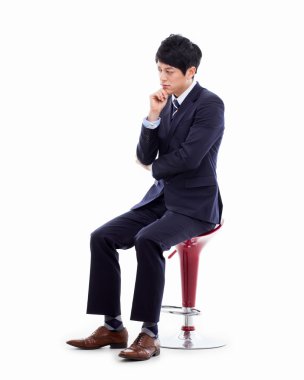 sandalyede oturan genç Asyalı iş adamı