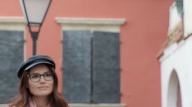 Gözlüklü genç bir kız kablosuz kulaklık takar ve akıllı bir telefondan müzik açar. Diş teli takan genç bir kadın mutlu bir şekilde gülümsüyor.