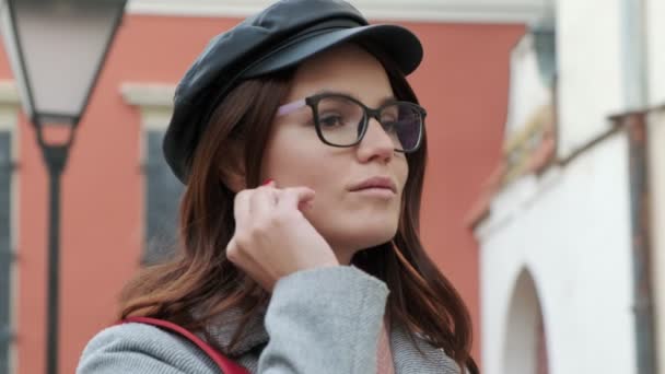 Młoda Piękna Dziewczyna Okularach Zakłada Słuchawki Bezprzewodowe Włącza Muzykę Smartfonie — Wideo stockowe