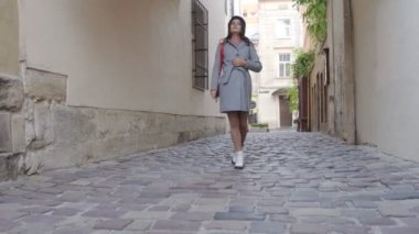 Genç ve güzel bir kız eski kasabada yürüyor ve mimariyi inceliyor. Dişlerinde diş teli olan genç bir kadın..