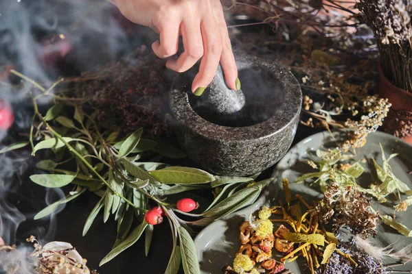 Kız kuru otları havanda öğütüyor. Çay, ilaç ve konserve yapmak için kurutulmuş otların karışımının hazırlanması. Beden eğitimi, alternatif tıp.. 