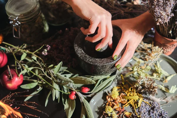 Kız kuru otları havanda öğütüyor. Çay, ilaç ve konserve yapmak için kurutulmuş otların karışımının hazırlanması. Beden eğitimi, alternatif tıp.. 