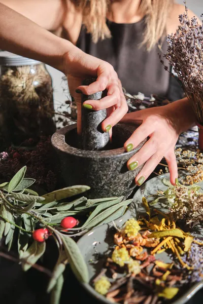 Kız kuru otları havanda öğütüyor. Çay, ilaç ve konserve yapmak için kurutulmuş otların karışımının hazırlanması. Beden eğitimi, alternatif tıp.. 
