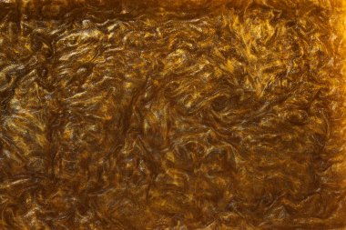 Sıvı altının dokusu ve parlak pigmentler. Dalgaların soyut altın dokusu, girdaplar. Altın likit akrilik boya. Modern tasarım ögesi. 