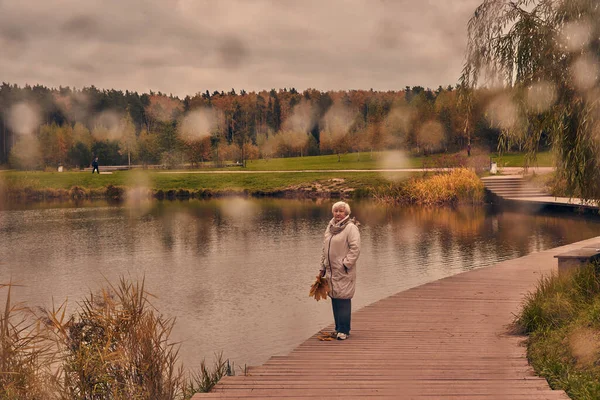 Schieten Door Nat Glas Een Oudere Vrouw Wandelt Een Herfstpark — Stockfoto