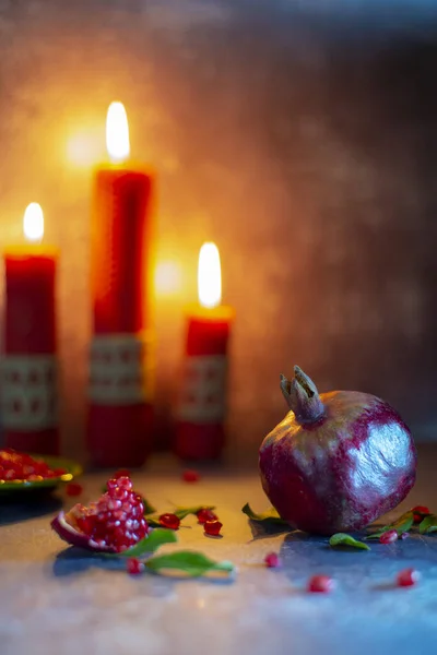 Zralé Šťavnaté Granátové Jablko Pozadí Hořících Červených Svíček — Stock fotografie