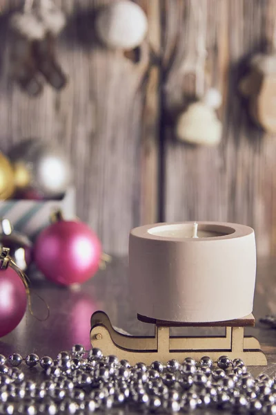 Yeni yıl dekorunun arka planında kil bir şamdanda el yapımı soya mumu..