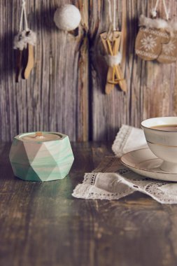 Yeni yıl dekorunun arka planında kil bir şamdanda el yapımı soya mumu..