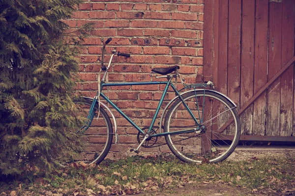 Uma Bicicleta Velha Está Contra Uma Parede Tijolo Grama Verde — Fotografia de Stock