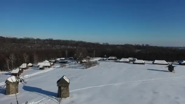 Vacaciones de Navidad o Año Nuevo. paisaje tradicional del pueblo en un día claro de invierno. Casas y campos cubiertos de nieve. — Vídeos de Stock