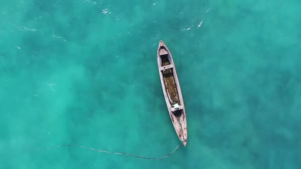 Zanzibar. Tanzania. Luchtopname van de vissersboten drijvend op turquoise Indische oceaan golven. Drone punt bovenaanzicht 4K beelden. — Stockvideo