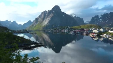 Okyanustaki parlak kırmızı evler. Norveç 'teki Lofoten adalarındaki küçük bir balıkçı köyünün görüntüleri. Popüler turizm merkezi
