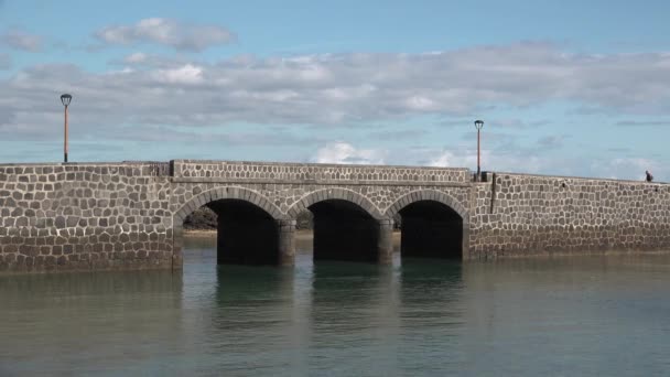 Brug naar het fort aan de kust van de Atlantische Oceaan. Stenen middeleeuwse brug over de baai van Lanzarot — Stockvideo