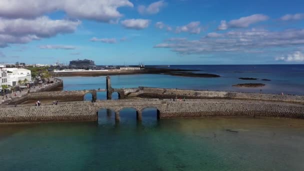 Ponte para a fortaleza nas margens do Oceano Atlântico. Ponte medieval de pedra através da baía do mar em Lanzarot — Vídeo de Stock