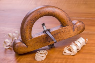 old router plane with shavings on a cherry wood board clipart