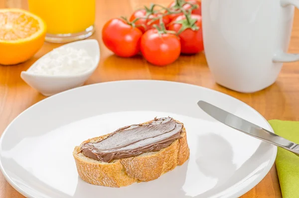 Stokbrood met hazelnoot crème op een ontbijttafel — Stockfoto