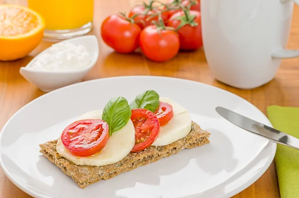 Pão de centeio com tomate e mussarela em uma mesa de café da manhã — Fotografia de Stock