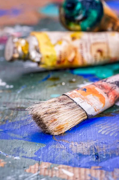 Pincel e cores de óleo em uma paleta de madeira — Fotografia de Stock