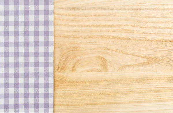 Фиолетовая клетчатая скатерть на деревянном фоне — стоковое фото