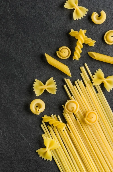 Different types of pasta on a slate background — Stock Photo, Image