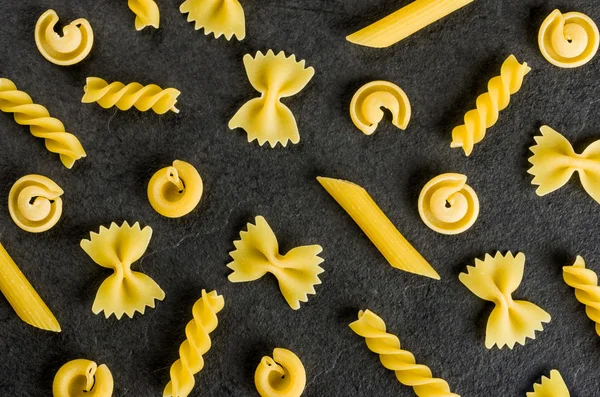 Diversi tipi di pasta su fondo di ardesia — Foto Stock