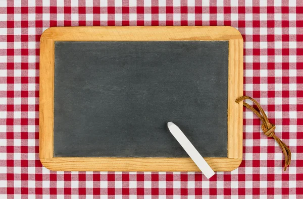 Leere Tafel mit Kreide auf einem rot karierten Tischtuch — Stockfoto