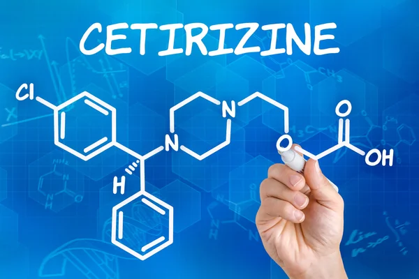 Hand with pen drawing the chemical formula of cetirizine — Stock Photo, Image
