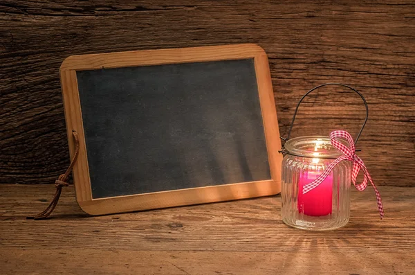 Kerze vor einer leeren Tafel — Stockfoto