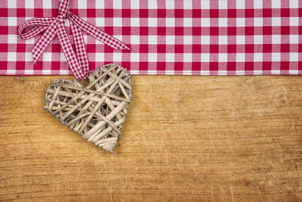 Fond en bois rustique avec un cœur tressé — Photo