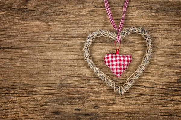 Rustieke houten achtergrond met een gevlochten hart — Stockfoto