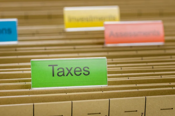 Hanging file folder labeled with Taxes — Stock Photo, Image