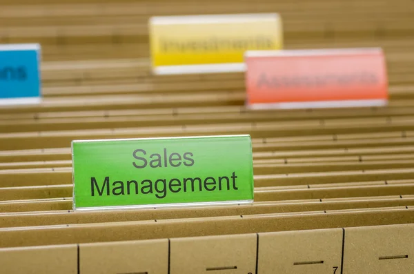 Hanging file folder labeled with Sales Management — Stock Photo, Image