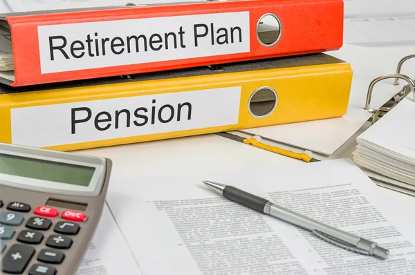 Папки с этикеткой пенсионного плана и пенсии — стоковое фото